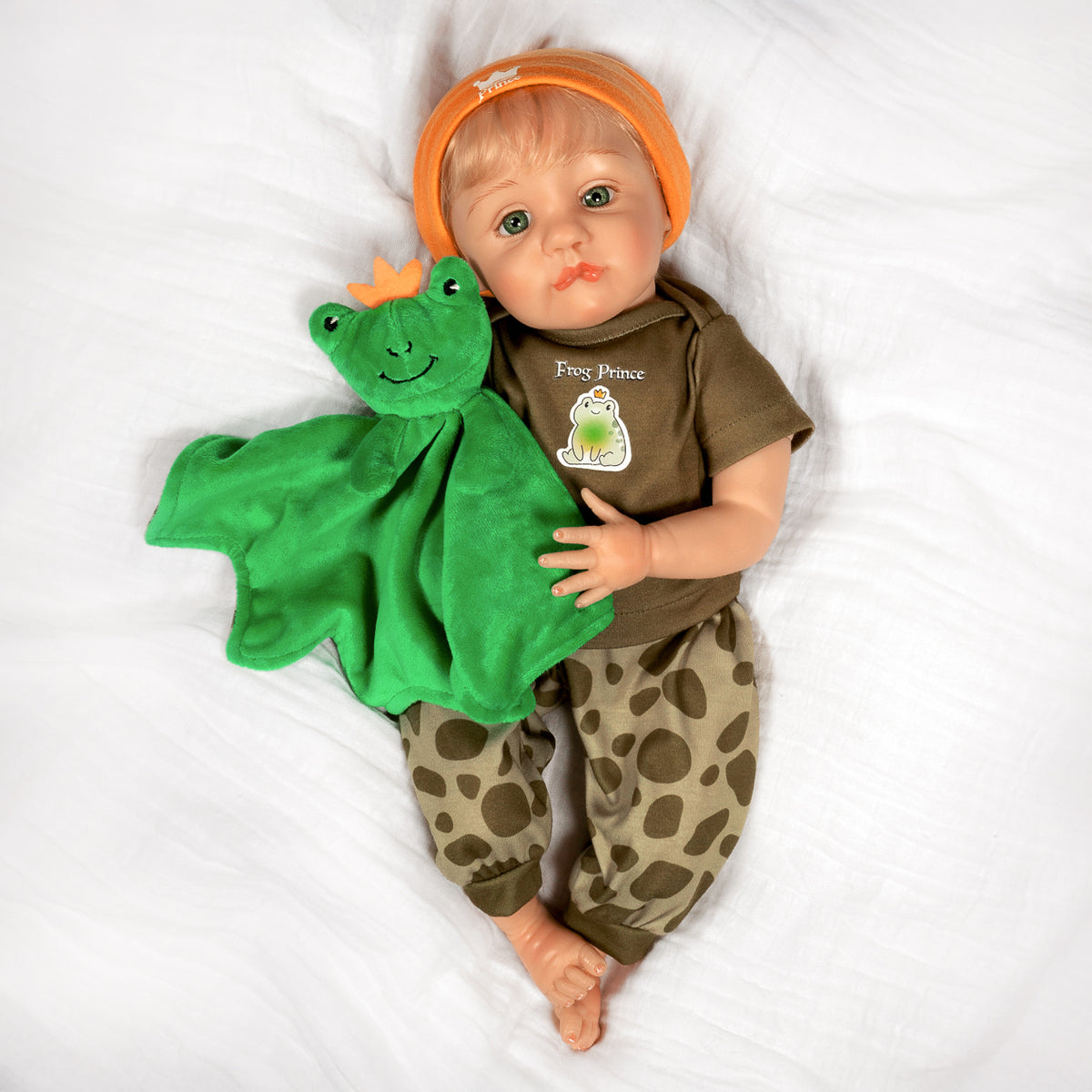 Frog Prince Realistic Blonde Boy Baby Doll  in frog prince outfit with green frog toy on white background